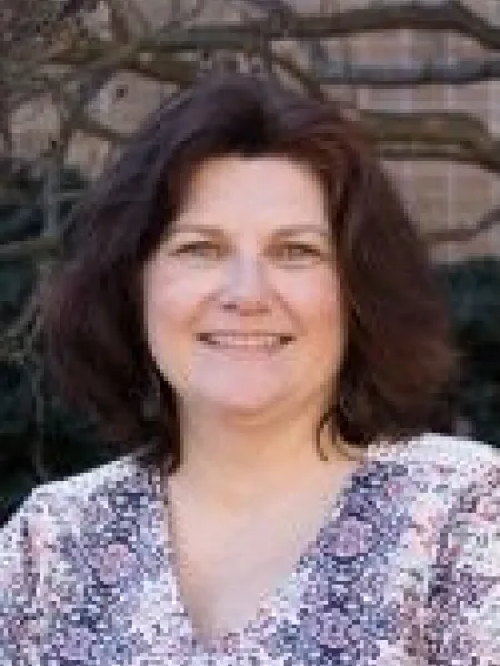 Person in purple and white blouse, posing for headshot.