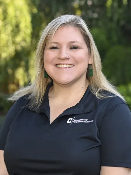 Person in black polo with UNC Charlotte logo, posing for headshot.