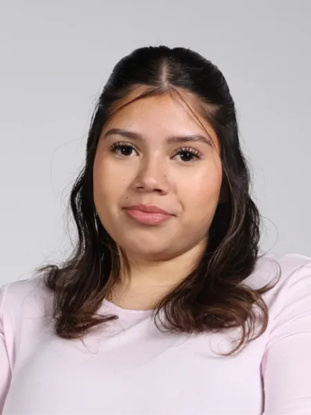 person in pink shirt with brown hair smiling