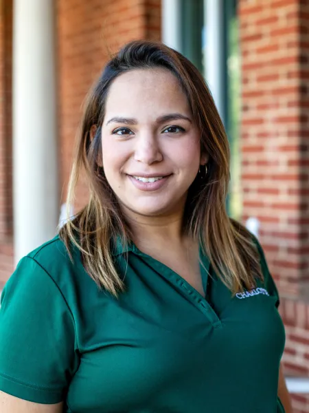 Woman in green polo posing for headshot