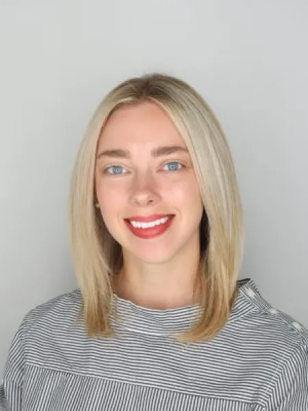 Person in black and white striped shirt posing for headshot.