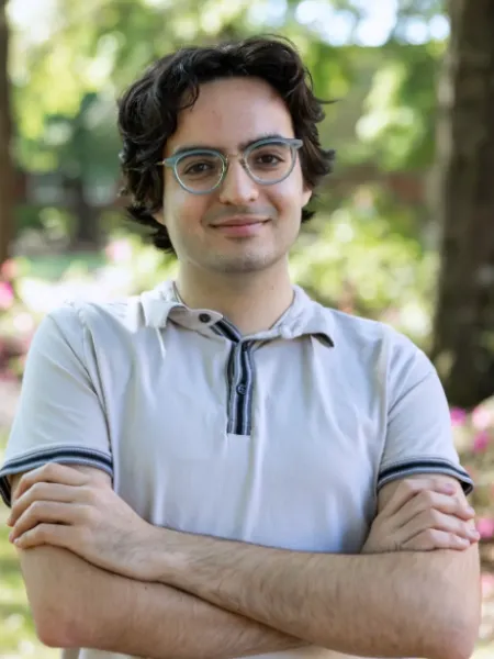 person smiling with glasses and arms crossed