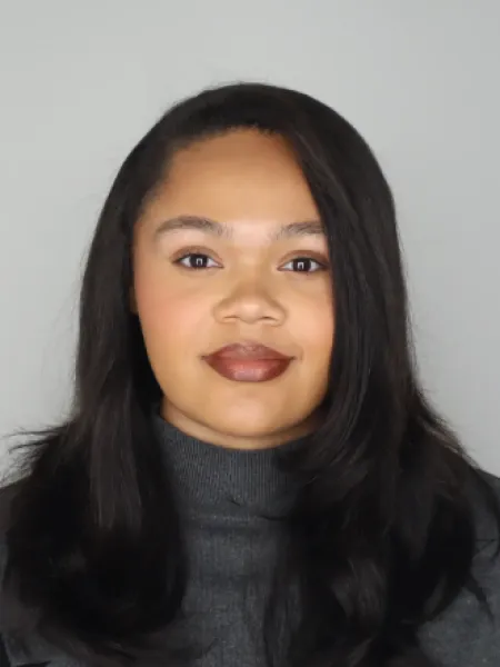 Person smiling wearing a grey turtleneck