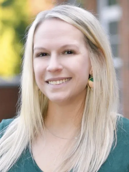 Person in green shirt posing for headshot.