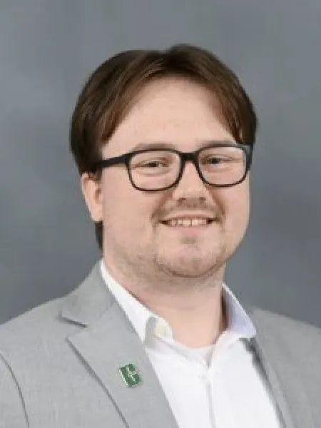person in front of gray background with glasses