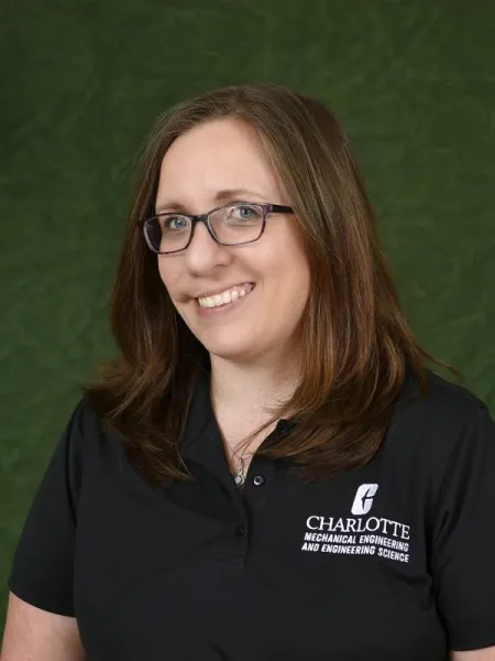 Person in polo shirt with UNC Charlotte logo for Mechanical Engineering and Engineering Science. Also posing for headshot.