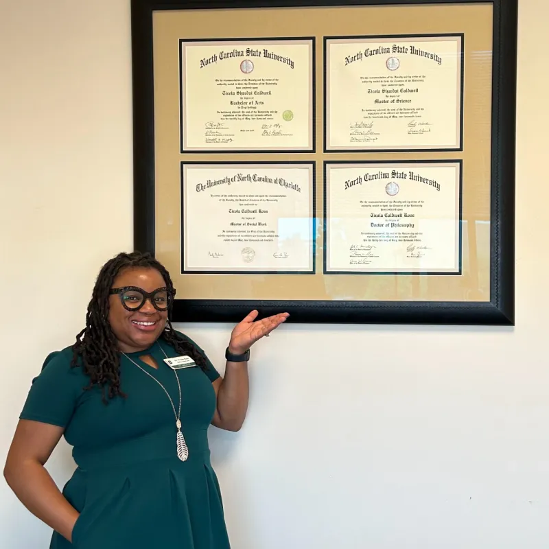 Person in green dress standing in front of four degrees