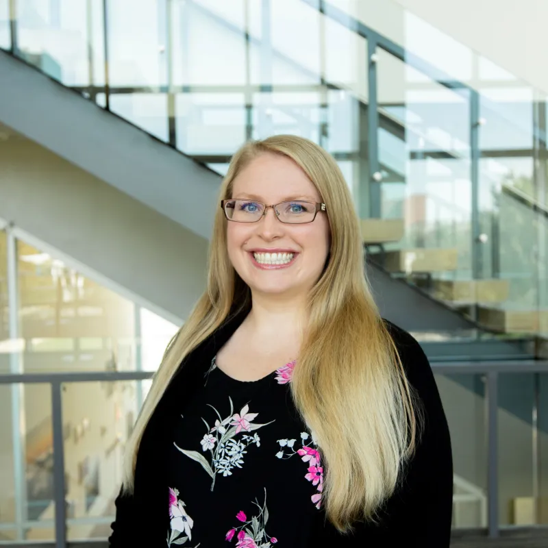 Woman wearing floral black shirt with long blonde hair