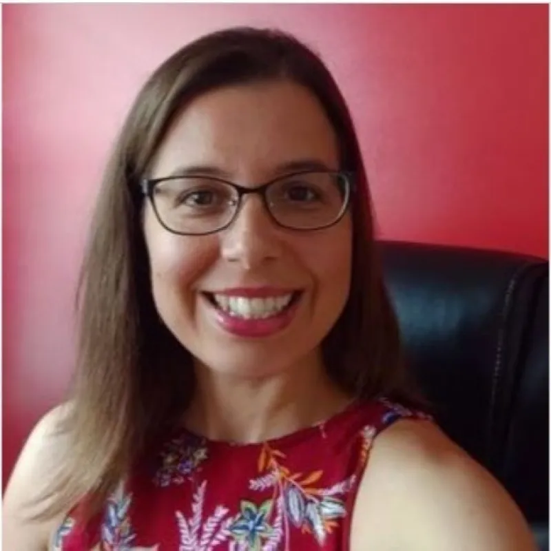 woman wearing dark glasses with a big smile and a red background